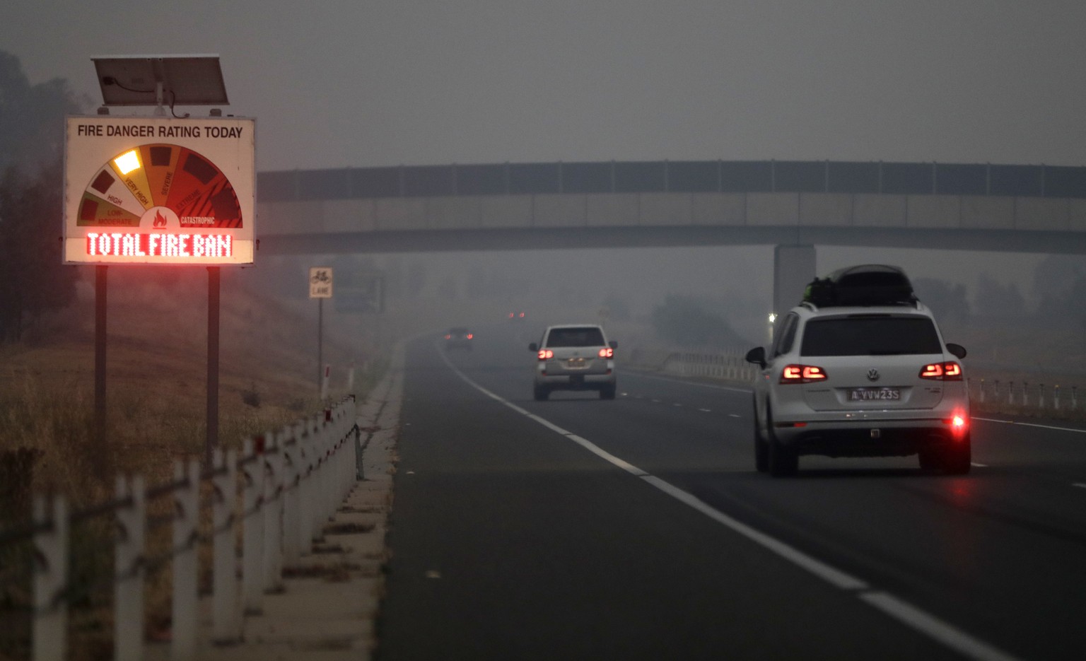 Cars drive down a freeway as smoke shrouds the Australian capital of Canberra, Australia, Wednesday, Jan. 1, 2020. Australia deployed military ships and aircraft to help communities ravaged by apocaly ...