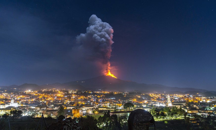 Flames and smoke billowing from a crater, as seen from the southern side of the Mt Etna volcano, tower over the city of Pedara, Sicily, Wednesday night, Feb. 24, 2021. Europe&#039;s most active volcan ...