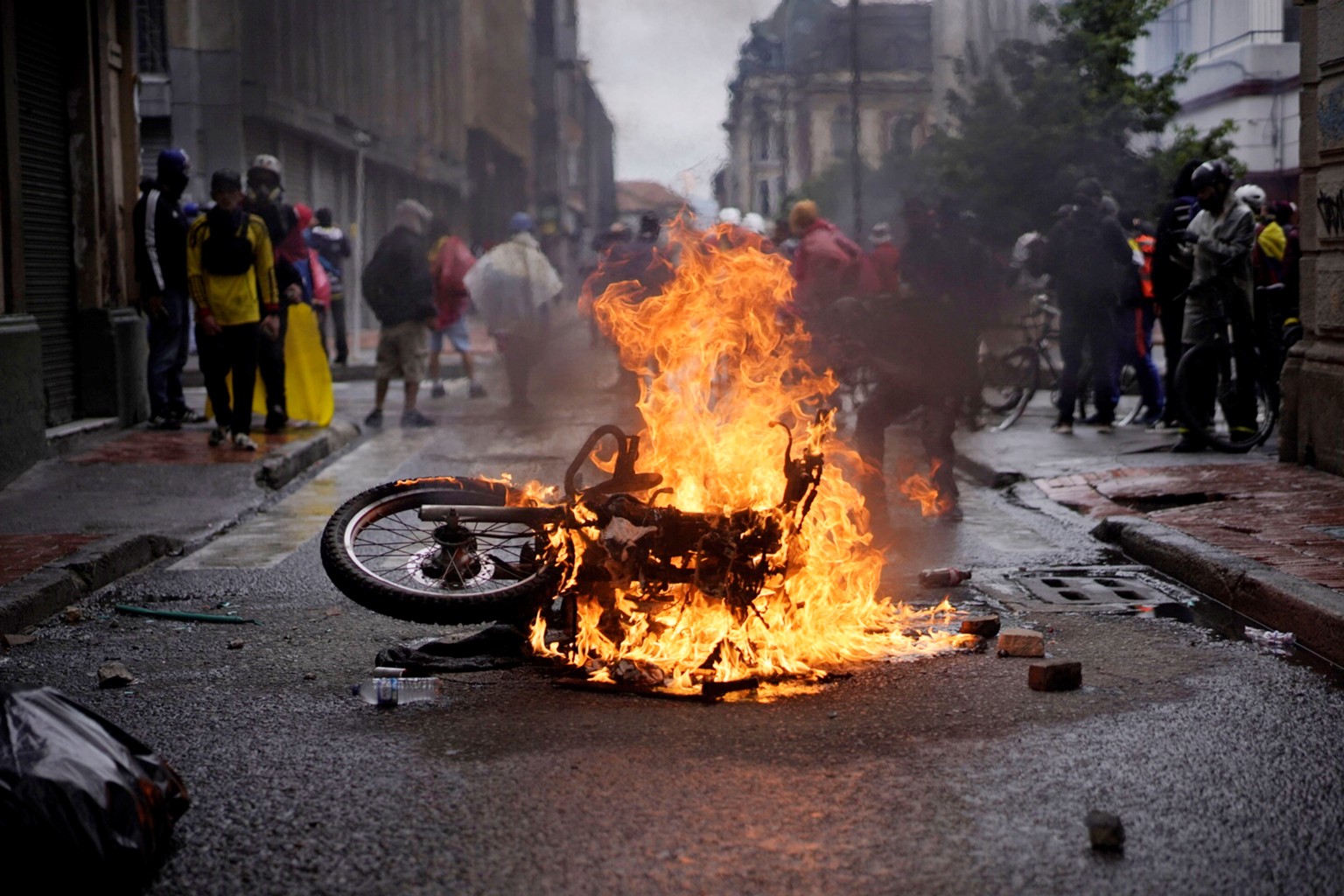 epa09180015 A motorcycle is set on fire during a new day of protests in Bogota, Colombia, 05 May 2021. A week into the protests, thousands continued to take to the streets against the government of Iv ...