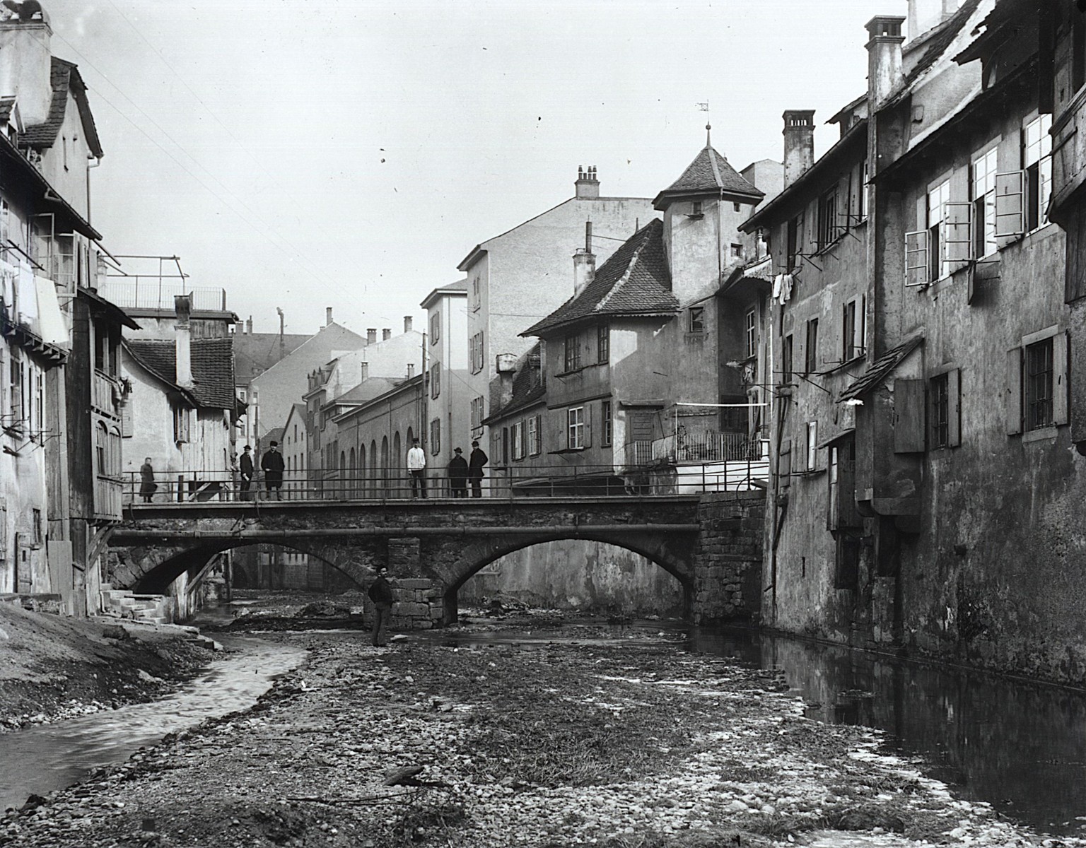 Die Klosterbergbrücke um 1886. Der Flusslauf des Birsigs durchs Wohnquartier.&nbsp;An der Rückseite der Häuser sieht man die angebauten «Plumpsklosetts».