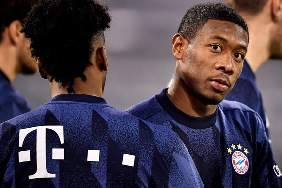 epa08864497 Bayern?s David Alaba (R) looks on as he warms up prior to the German Bundesliga soccer match between FC Bayern Munich and RB Leipzig at Allianz Arena in Munich, Germany, 05 December 2020.  ...