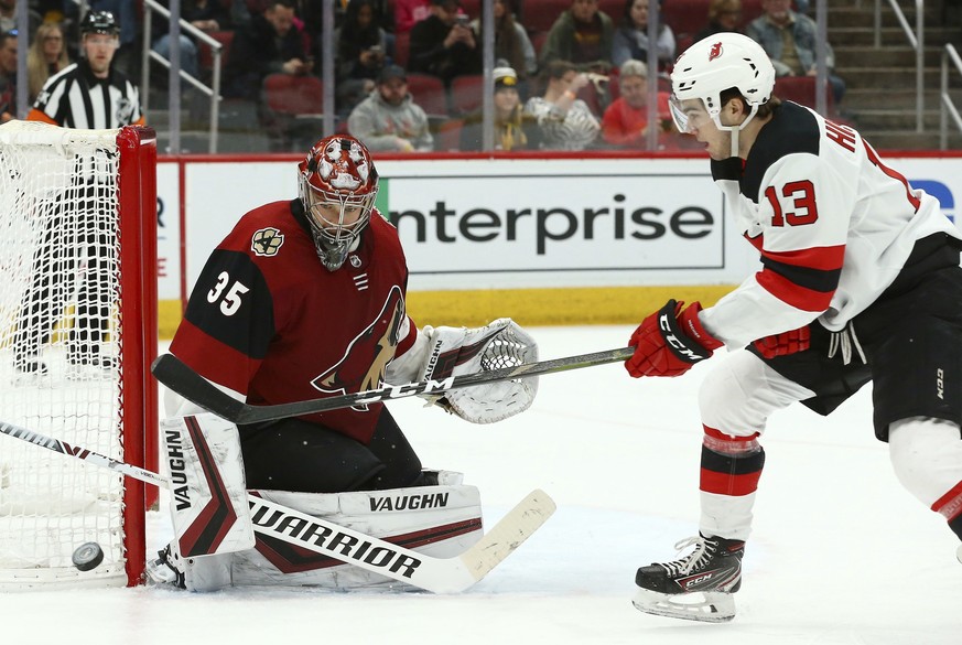 Arizona Coyotes goaltender Darcy Kuemper (35) makes a save on a shot by New Jersey Devils center Nico Hischier (13) during the first period of an NHL hockey game Friday, Jan. 4, 2019, in Glendale, Ari ...
