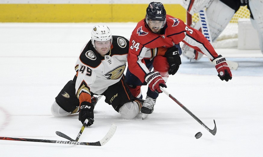 Washington Capitals defenseman Jonas Siegenthaler (34) and Anaheim Ducks left wing Max Jones (49) battle for the puck during the third period of an NHL hockey game, Monday, Nov. 18, 2019, in Washingto ...