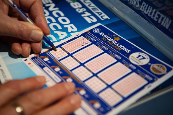 epa08862326 A person plays a EuroMillions grid in Bordeaux, France, 04 December 2020. The jackpot for this draw will reach 200 million euro. Before 2020, the jackpot was capped at 190 million euros. E ...