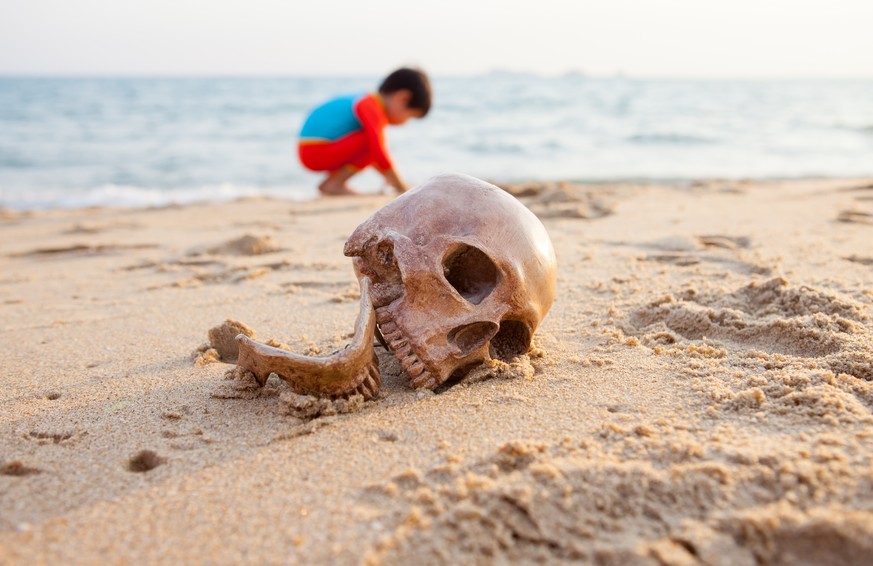 death on the beach strand schädel totenkopf tod tot kind junge spielen sand sandstrand meer