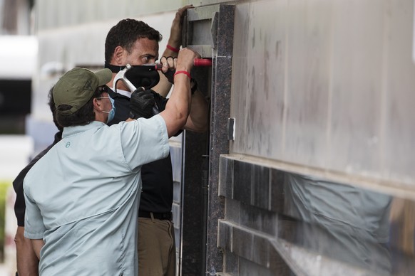 Federal officials and a locksmith work on a door to make entry into the vacated Consulate General of China building Friday, July 24, 2020, in Houston. On Tuesday, the U.S. ordered the Houston consulat ...