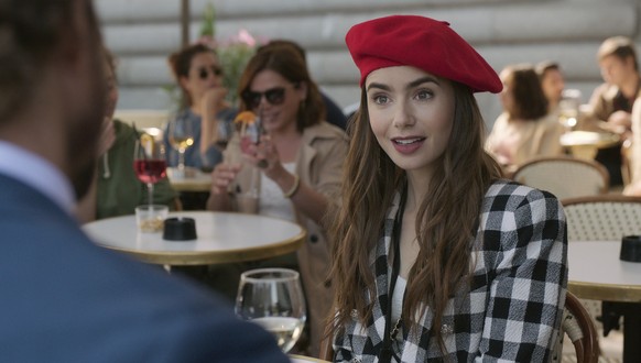 This image released by Netflix shows Lily Collins in a scene from the series &quot;Emily in Paris,&quot; premiering on Friday. (Netflix via AP)