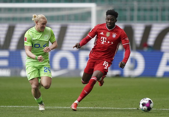 Bayern&#039;s Alphonso Davies, right, and Wolfsburg&#039;s Xaver Schlager challenge for the ball during the German Bundesliga soccer match between VfL Wolfsburg and FC Bayern Munich in Wolfsburg, Germ ...