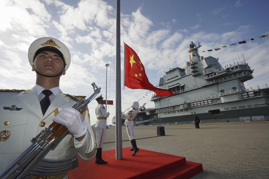 FILE - In this Dec. 17, 2019, file photo and released by Xinhua News Agency, Chinese honor guard raise the Chinese flag during the commissioning ceremony of China&#039;s Shandong aircraft carrier at a ...