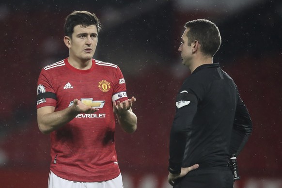 epa08834857 Harry Maguire (L) of Manchester United argues with referee David Coote (R) after he awarded a penalty during the English Premier League soccer match between Manchester United and West Brom ...
