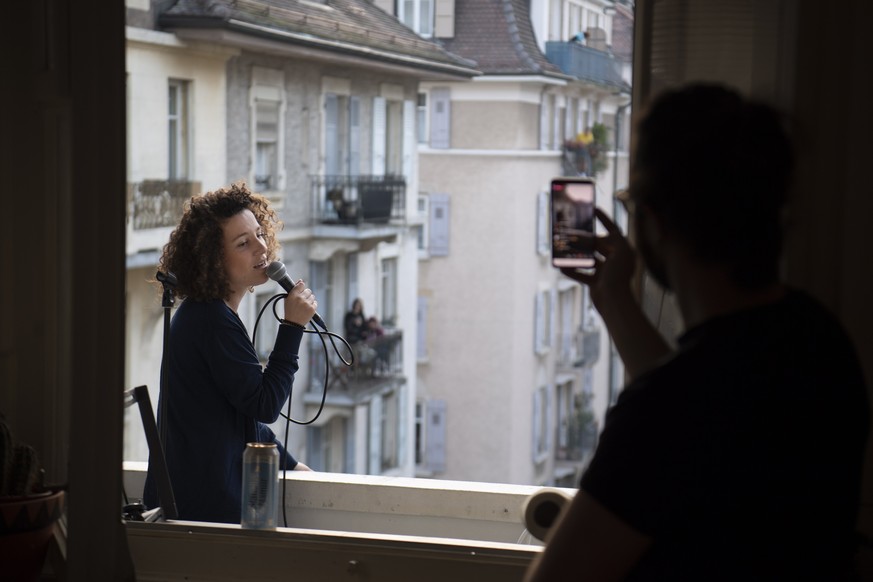 epa08329209 Swiss singer and semifinalist of French TV reality show The Voice in 2016 Amandine (Rapin) performs a short concert on her balcony during the state of emergency of the coronavirus disease  ...