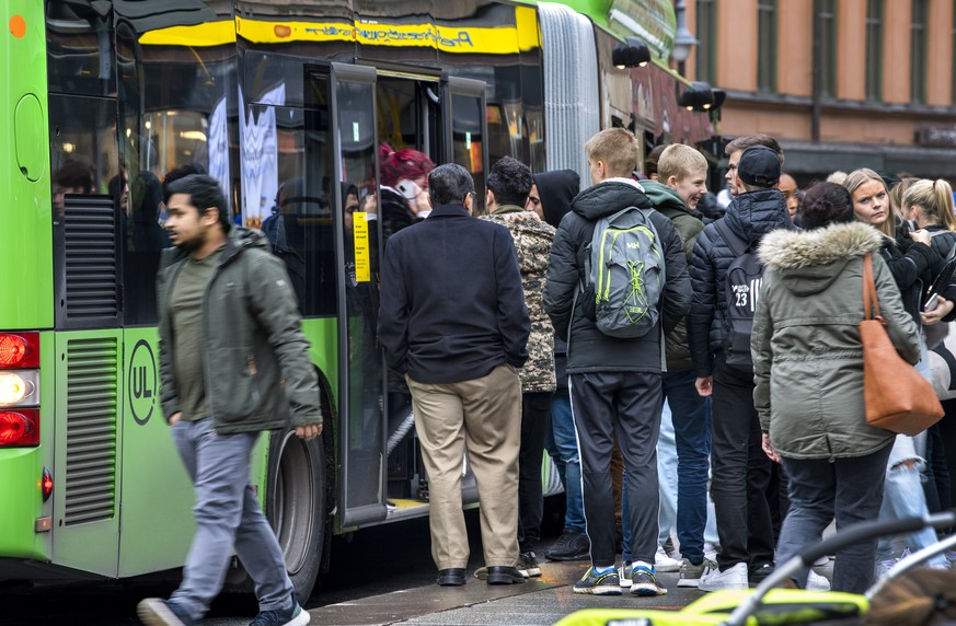 epa08761813 People board a local bus in central Uppsala, Sweden, 21 October 2020. Due to an increase of Covid-19 cases in the region of Uppsala, new local recommended restrictions has been instated to ...
