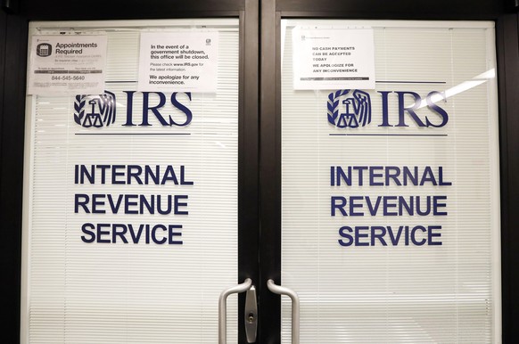 FILE - In this Jan. 16, 2019, file photo, doors at the Internal Revenue Service (IRS) in the Henry M. Jackson Federal Building are locked and covered with blinds as a sign posted advises that the offi ...
