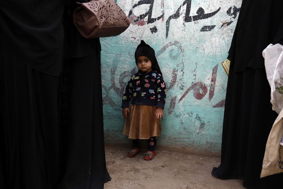 epa08308141 A Yemeni child (C) waits her mother lining up to get free food ration from a charity group in Sanaa, Yemen, 17 March 2020 (issued 19 March 2020). Over 24 million people in Yemen are in des ...