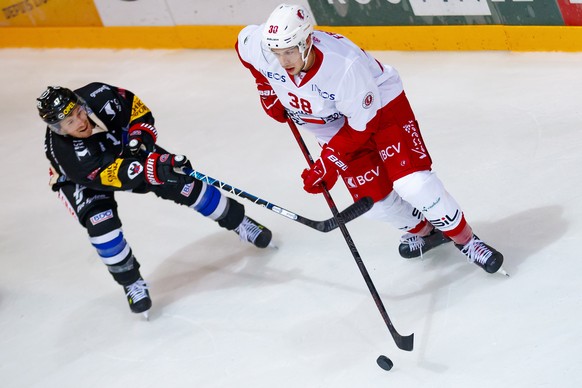 L&#039;attaquant fribourgeois Andrew Miller, gauche, lutte pour le puck avec le defenseur lausannois Lukas Frick, droite, lors de la rencontre du championnat suisse de hockey sur glace de National Lea ...