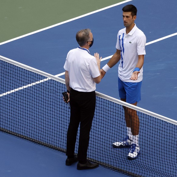 epa08651693 Head of Officiating at International Tennis Federation (ITF) Soeren Friemel (L) talks to Novak Djokovic of Serbia (R) after he accidentally hit a linesperson with a ball in the throat duri ...