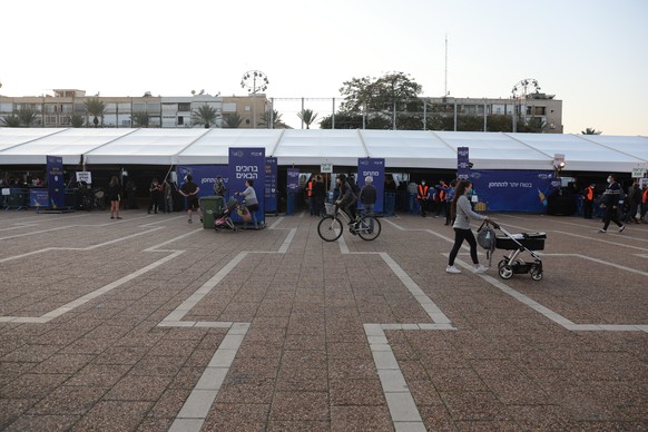 epa08912563 People wait in a line to receive COVID-19 vaccine outside the new Tel Aviv municipality vaccines center in Rabin square, Tel Aviv, Israel, 31 December 2020. Media report that Israel is on  ...