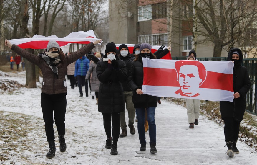 epa08881450 Protesters covered in flags take part in a rally against the government and President Lukashenko in Minsk, Belarus, 13 December 2020. Opposition activists continue their protests, calling  ...