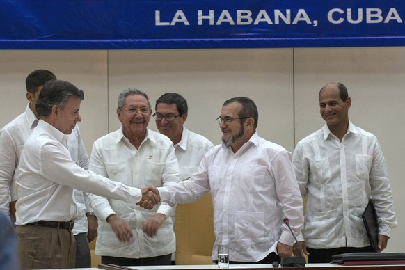 Kubas Präsident Raul Castro, in der Mitte, Kolumbiens Präsident Juan Manuel Santos, links, FARC-Kommandeur Timoleon Jimenez in Havanna, Kuba.