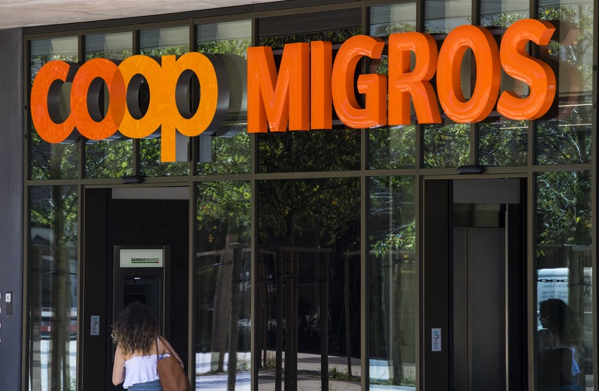 Le logo de la Coop et le logo de la Migros sont photographies cote a cote sur un batiment commercial commun ce mardi 23 aout 2016 sur la place de la Sallaz a Lausanne. (KEYSTONE/Jean-Christophe Bott)
