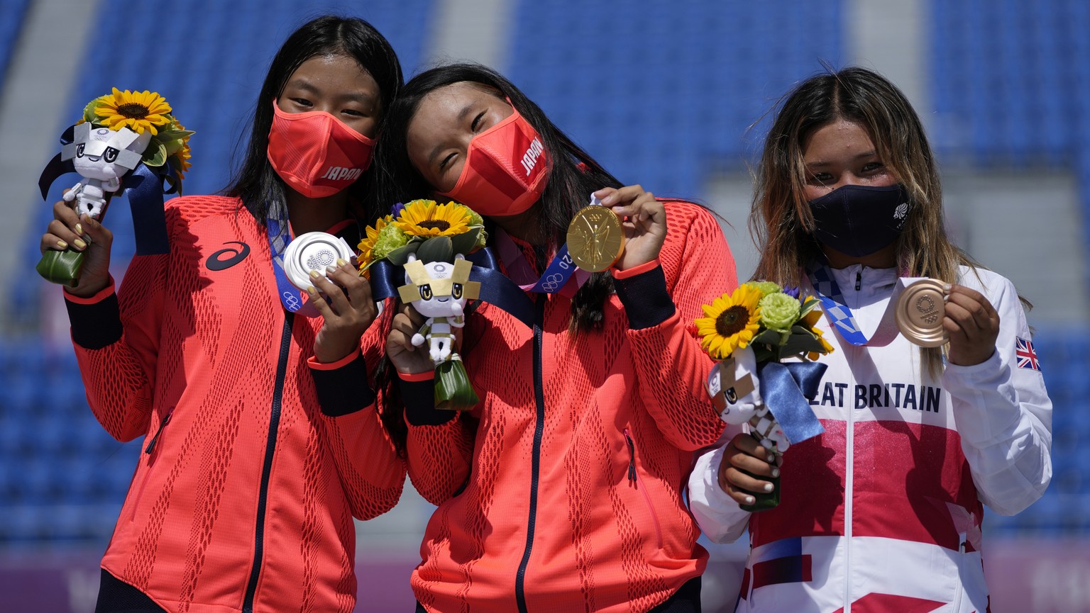From left, silver medalist Kokona Hiraki of Japan, gold medalist Sakura Yosozumi of Japan and bronze medalist Sky Brown of Britain pose during a medals ceremony for the women&#039;s park skateboarding ...