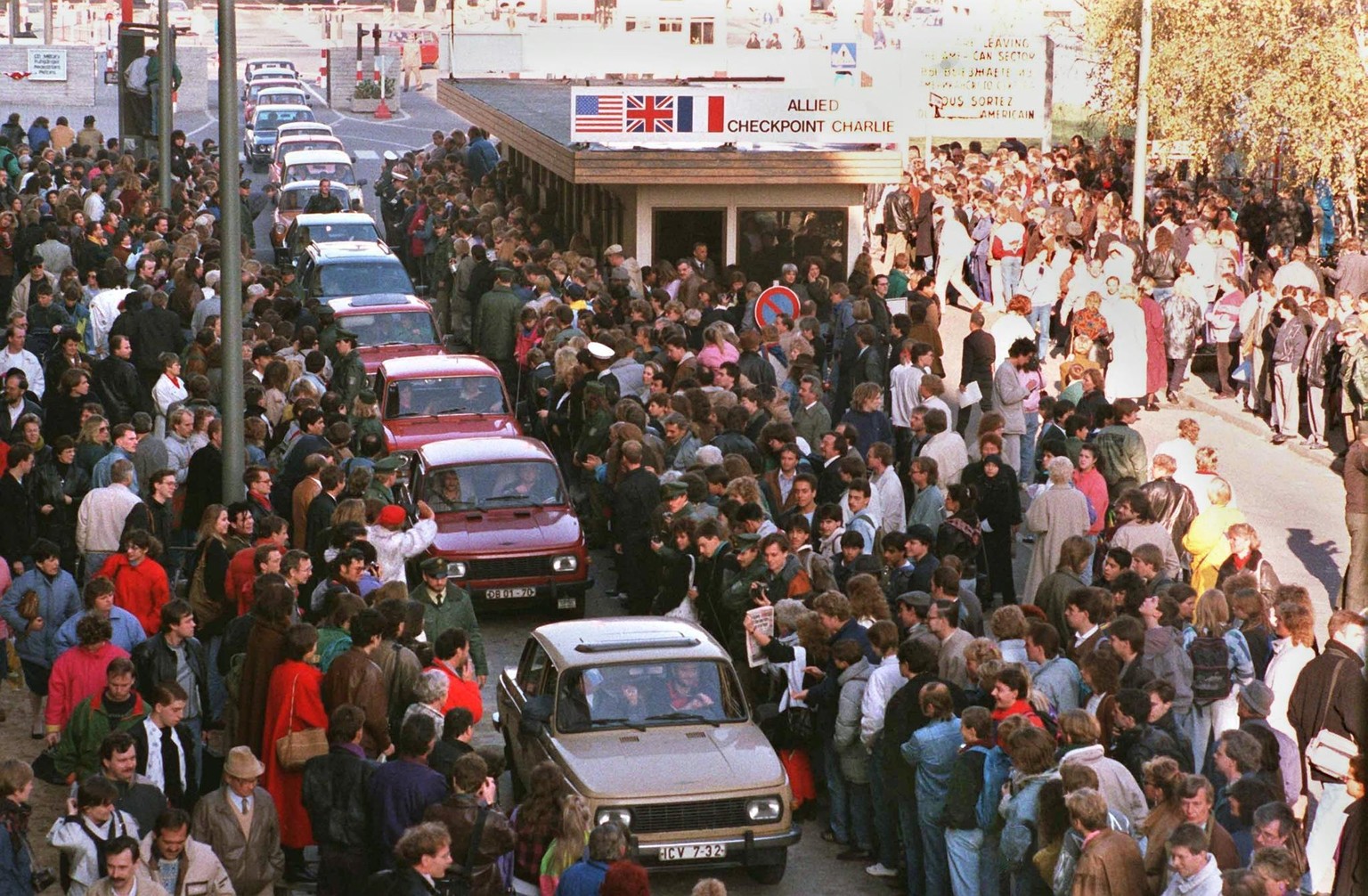 A long row of East German Trabant cars passing through Checkpoint Charlie into West Berlin is greeted by enthusiastic West Berliners, 10th November 1989. (Photo by EPA PHOTOS DPA FILES/AFP/Getty Image ...