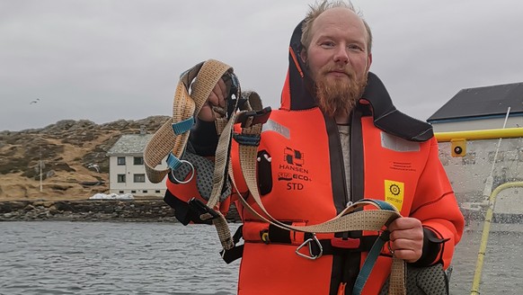 Norwegian Joergen Ree Wiig holds the whale harness after it was removed from a beluga whale off the northern Norwegian coast Friday, April 26, 2019. The harness strap which features a mount for an act ...
