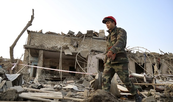 A soldier walks past a destroyed house in a residential area that was hit by rocket fire overnight by Armenian forces, early Saturday, Oct. 17, 2020, in Ganja, Azerbaijan&#039;s second largest city, n ...