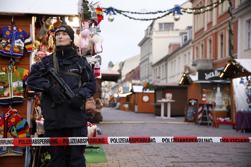 epa06361972 A police officer stands guard behind a police line at the otherwise bustling Potsdam Christmas market, now empty after it was evacuated by police, Potsdam, Germany, 01 December 2017. Polic ...