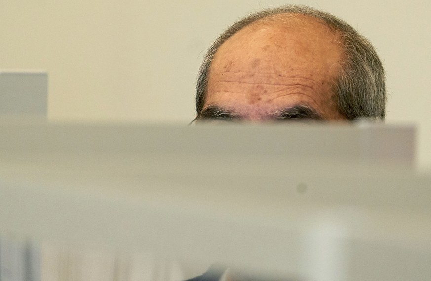 One of the defendants, Anwar R. (57), sits in the dock of the Higher Regional Court behind Corona protective screens, hiding his face under a hood in Koblenz, Germany, Thursday, April 23, 2020. Two fo ...