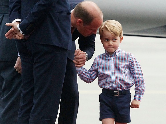 FILE - In this Monday, July 17, 2017 file photo, Britain&#039;s Prince William, left, holds the hand of his son Prince George on their arrival at the airport, in Warsaw, Poland. An alleged supporter o ...