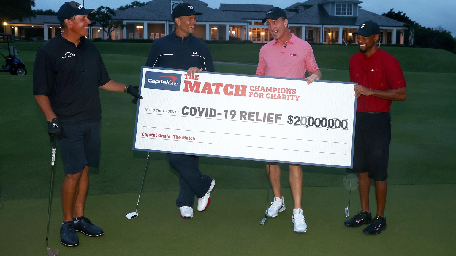 epa08442153 A handout photo made available by Getty Images for the Match shows United States golfer Tiger Woods (R) and former National Football League (NFL) player Peyton Manning (2-R) celebrating de ...