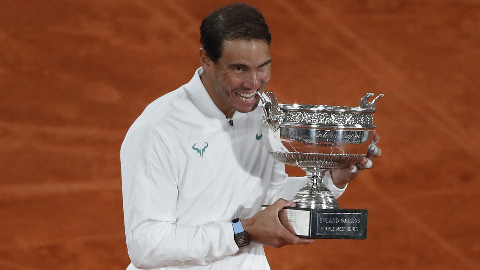 Spain&#039;s Rafael Nadal bites the trophy as he celebrates winning the final match of the French Open tennis tournament against Serbia&#039;s Novak Djokovic in three sets, 6-0, 6-2, 7-5, at the Rolan ...