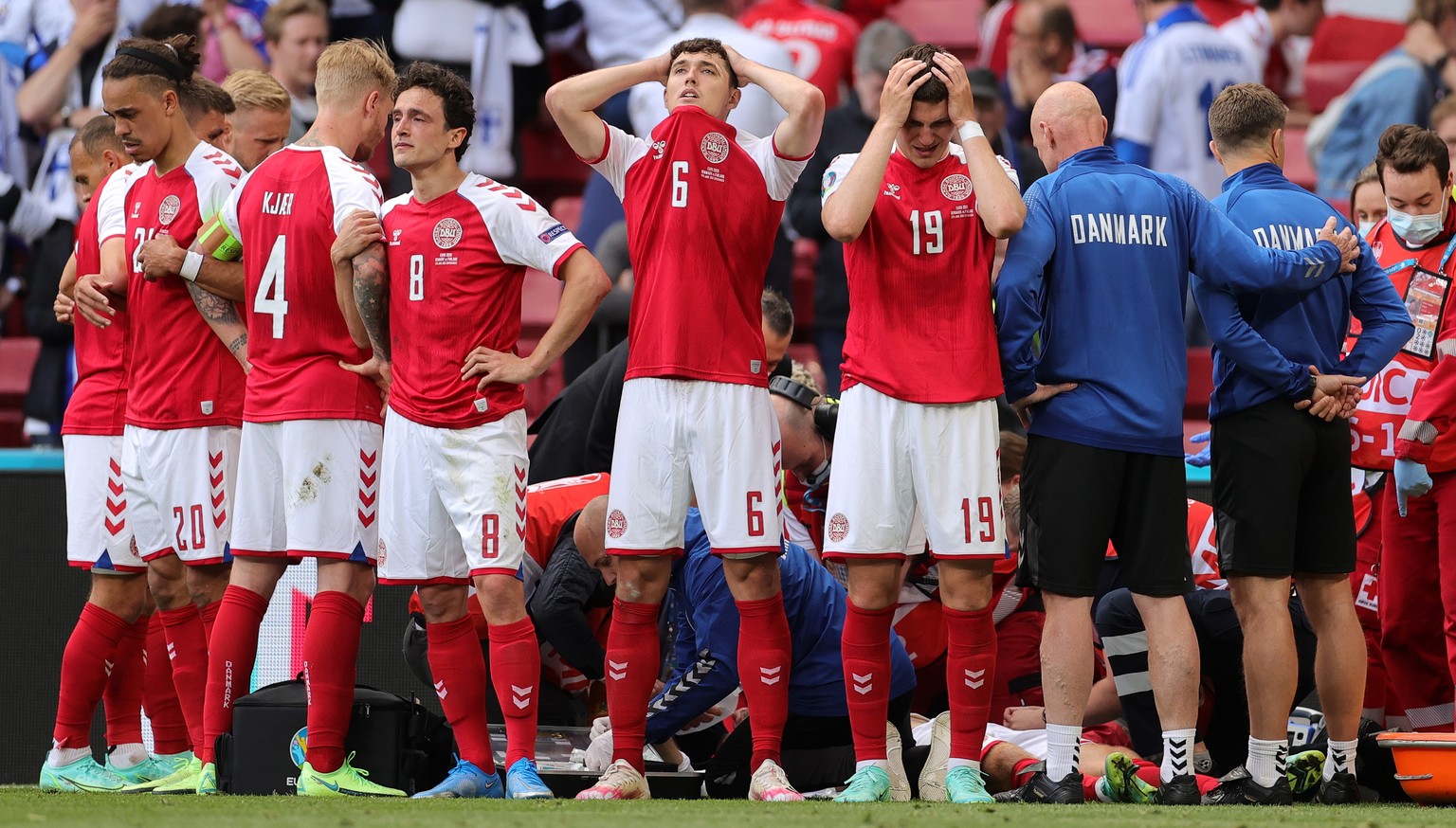epa09266507 Players of Denmark react while their teammate Christian Eriksen receives medical treatment during the UEFA EURO 2020 group B preliminary round soccer match between Denmark and Finland in C ...