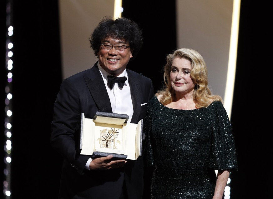 epa07600276 South Korean director Bong Joon-ho (L) accepts the Palme d&#039;Or (Golden Palm) for the movie &#039;Parasite&#039; from French actress Catherine Deneuve (R) during the Closing Awards Cere ...