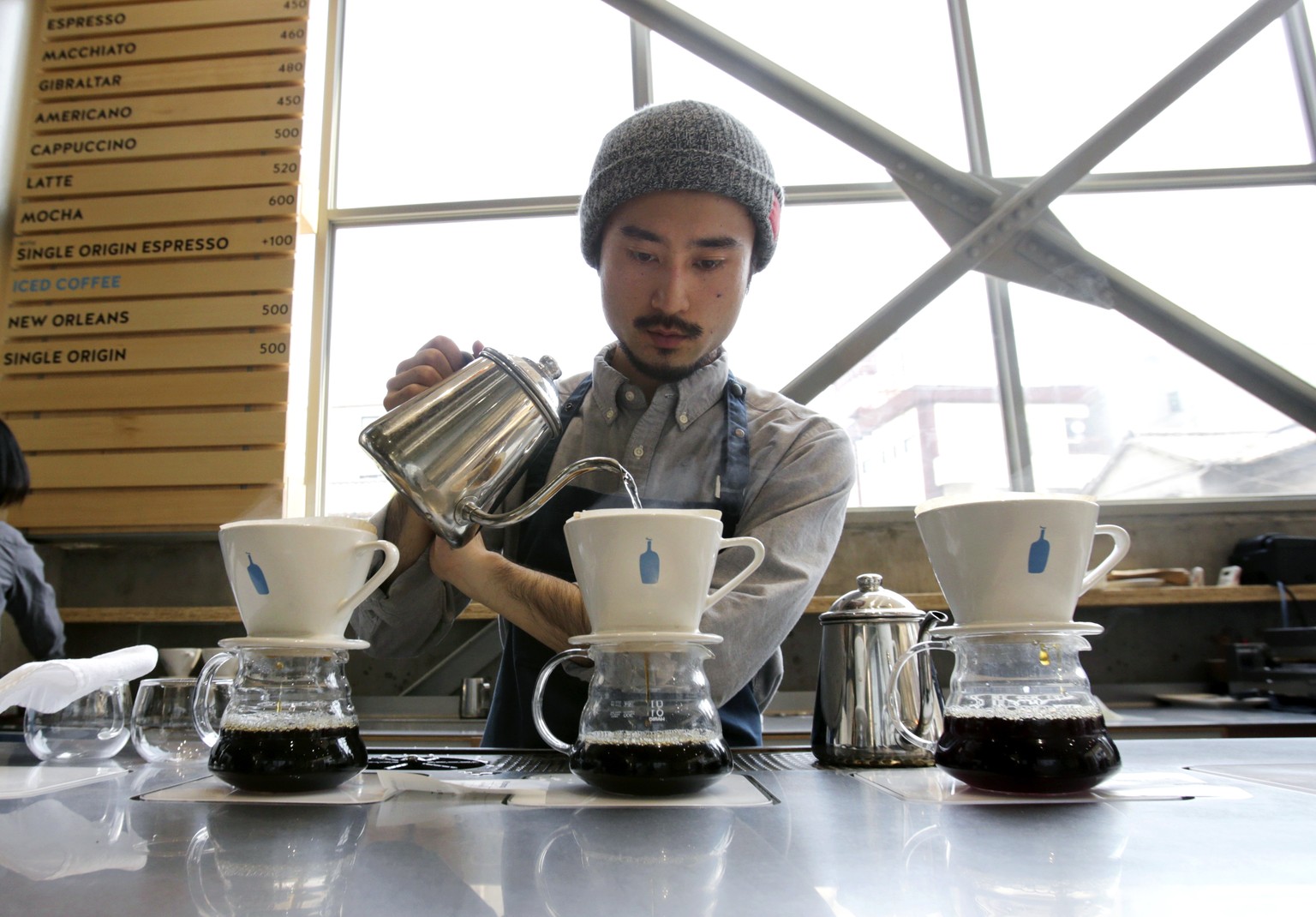 In this April 27, 2015 photo, a barista brews coffee at a Blue Bottle Coffee shop in Tokyo. Japan, famous for green tea, is welcoming artisanal American coffee roaster Blue Bottle with long lines that ...