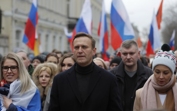 epa08258771 Russian opposition leader and anti-corruption activist Alexei Navalny (C) walks alongside his spouse Yulia Navalnaya (R) and lawyer, Lyubov Sobol (L), as they take part in a memorial march ...