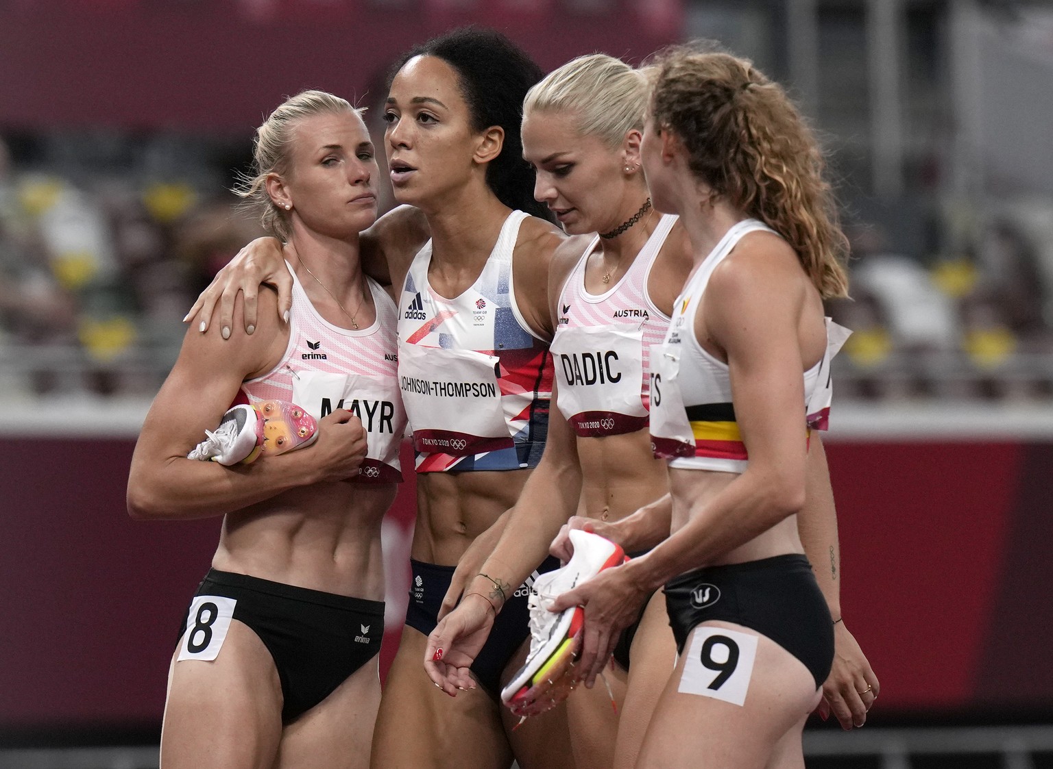 Katarina Johnson-Thompson, of Britain, second left, is consoled by other competitors after pulling up injured in the heptathlon 200-meters at the 2020 Summer Olympics, Wednesday, Aug. 4, 2021, in Toky ...