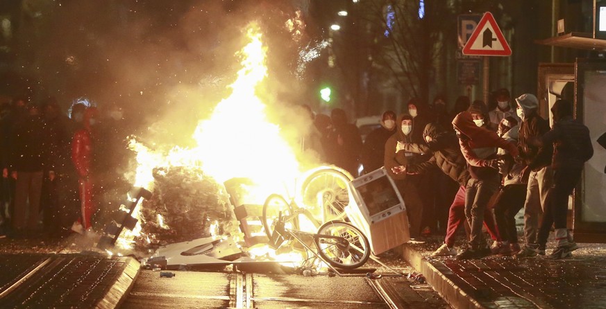 epa08935496 Rioters set a barricade on fire after a protest in demand for justice in the case of Ibrahim, 23, who died on 09 January, in Brussels, Belgium, 13 January 2021. The Brussels public prosecu ...