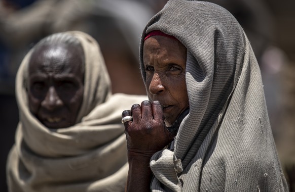 FILE - In this Saturday, May 8, 2021, file photo, a woman waits to receive foodstuffs such as wheat, yellow split peas and vegetable oil at a food distribution operated by the Relief Society of Tigray ...