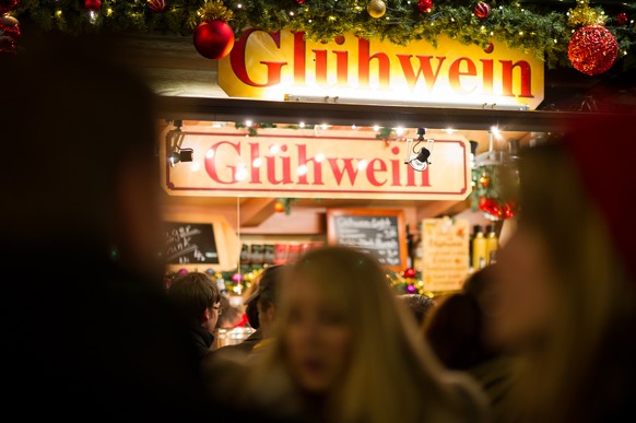 MUNICH, GERMANY - NOVEMBER 27: Visitors sip Gluehwein at a stall at the annual Christmas market on Marienplatz square on the market&#039;s opening day on November 27, 2014 in Munich, Germany. Christma ...