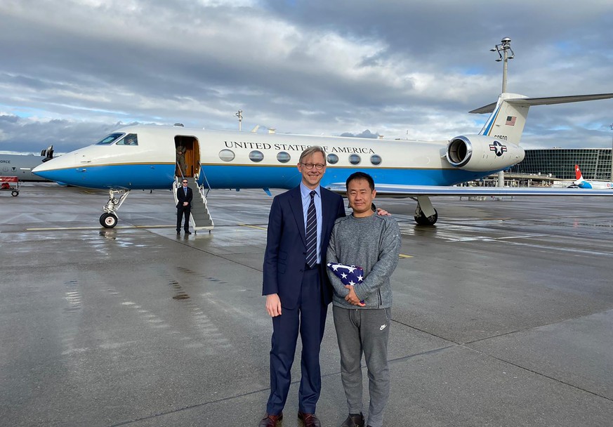 This photo provided by the U.S. State Department, U.S. special representative for Iran, Brian Hook stands with Xiyue Wang in Zurich, Switzerland on Saturday, Dec. 7, 2019. In a trade conducted in Zuri ...