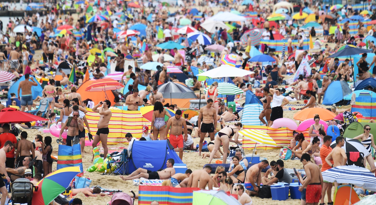 epa08591611 People gather to relax on the beach and seafront in Bournemouth, Britain, 08 August 2020. Britain is in the midst of a heatwave which could see record breaking temperatures according to so ...