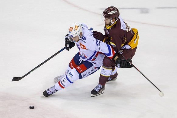 Lions&#039; defender Maxim Noreau, of Canada, left, vies for the puck with Geneve-Servette&#039;s forward Guillaume Maillard, right, during a National League regular season game of the Swiss Champions ...