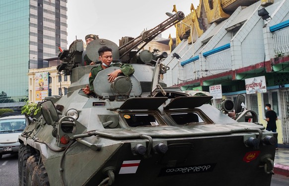 epa09012446 Soldiers in armoured vehicles drive along the street outside Sule Pagoda in Yangon, Myanmar, 14 February 2021. Protests against the military coup continued across the country despite order ...