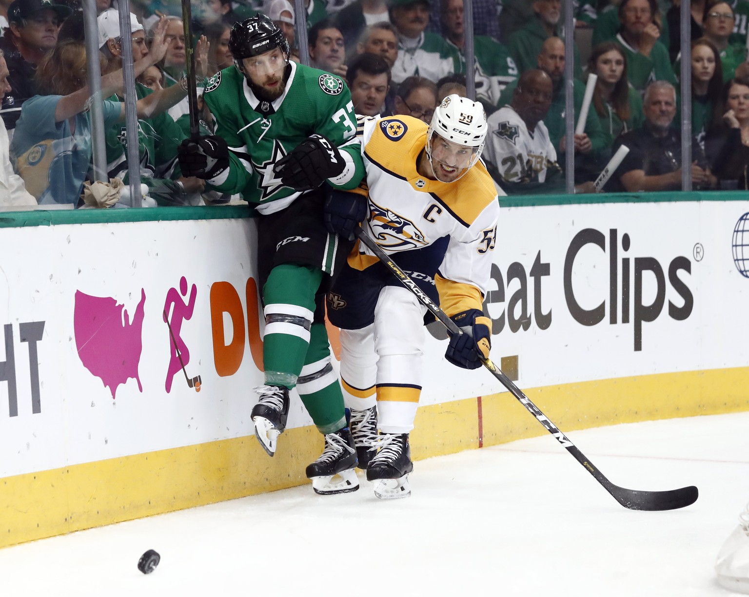 Dallas Stars&#039; Justin Dowling (37) and Nashville Predators&#039; Roman Josi (59) slam against the boards chasing after the puck in the first period of Game 6 in an NHL hockey first-round playoff s ...
