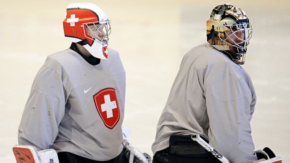 Switzerland&#039;s goaltenders Leonardo Genoni, left, and Reto Berra, right, look their teammates, during a Swiss team training optional session, at the IIHF 2018 World Championship, at the practice a ...