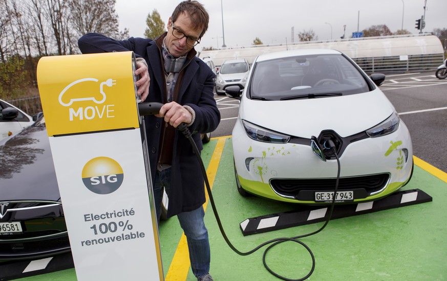 Un homme branche sa voiture electrique a une borne electrique de recharge rapide du parking P+R Bernex, lors d&#039;une presentation a la presse, ce lundi, 14 novembre 2016, a Bernex pres de Geneve. ( ...