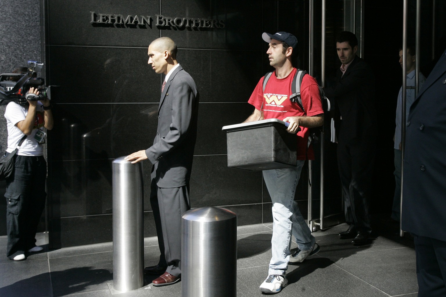 A man leaves the Lehman Brothers headquarters carrying a box, Monday, Sept. 15, 2008 in New York. Lehman Brothers, a 158-year-old investment bank choked by the credit crisis and falling real estate va ...