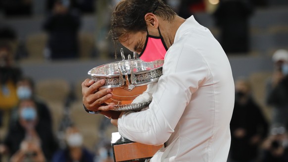 Spain&#039;s Rafael Nadal holds the trophy as he celebrates winning the final match of the French Open tennis tournament against Serbia&#039;s Novak Djokovic in three sets, 6-0, 6-2, 7-5, at the Rolan ...